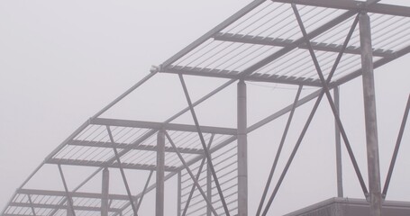 The tall steel structure amid the fog shows significant construction progress has been made