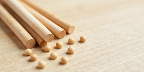 Close-up view of natural wooden dowels and small round beads scattered on a light wood surface