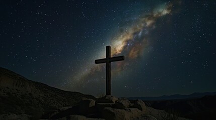 Starry night sky with milky way and cross silhouette in rocky desert landscape