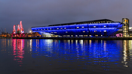 Illuminated Maritime Museum and cranes on the Lasztownia quay in Szczecin at night. Night panorama of the city of Szczecin.