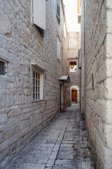 Morning walk along a romantic narrow street in the old town of Trogir on the Adriatic coast, Dalmatia, Croatia