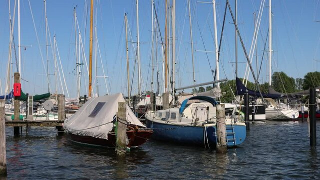 Sailboats moored at a marina of arnis in germany, gently sway on a sunny day