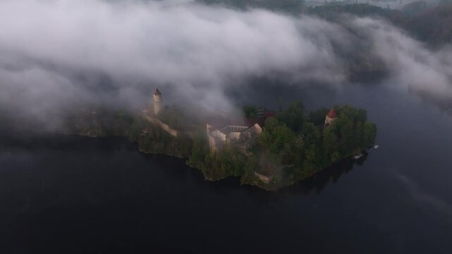 Aerial view of Zvikov Castle surrounded by the Moldau river in a serene sunrise with mist and fog, Zvikovske Podhradi, Czech Republic.