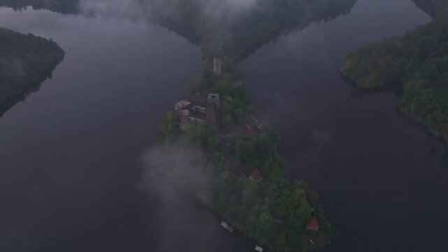 Aerial view of Zvikov Castle surrounded by the Moldau river in fog at sunrise, Zvikovske Podhradi, Czech Republic.