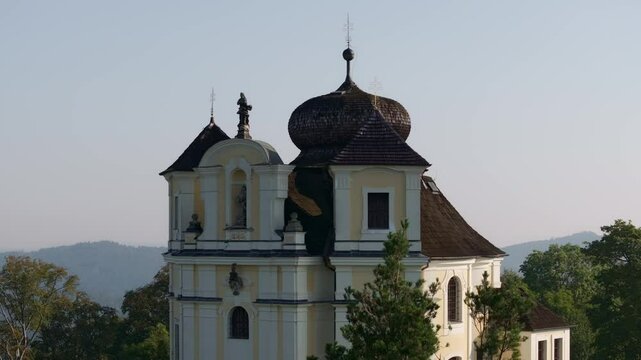 Aerial view of kostel sv. jana krtitele a panny marie karmelske church surrounded by beautiful trees and scenic nature, Smolotely, Czech Republic.