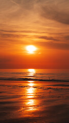 Obraz premium Magnificent sunset over the sea, casting warm colors across the sky and reflecting on the calm waters.
