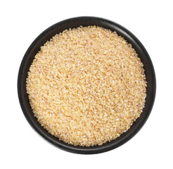 Raw wheat groats in bowl isolated on white, top view