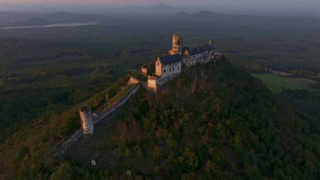 Aerial view of bezdez castle at sunset surrounded by forest and mountains, bezdez, czech republic.