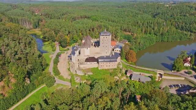 Aerial view of kost castle surrounded by lush forest and a winding river, Dobsin, Czech Republic.