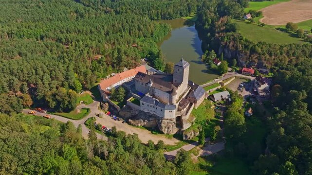 Aerial view of kost castle surrounded by lush forest and a winding river, Dobsin, Czech Republic.