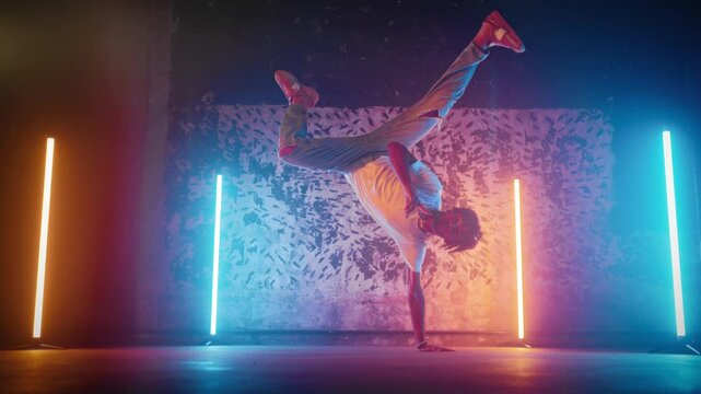 B-boying and Breakdancing, black man dancing in modern studio with bright light. Freestyle dancer enjoying music, expressing his emotions, feeling energy in body, African American guy breaking