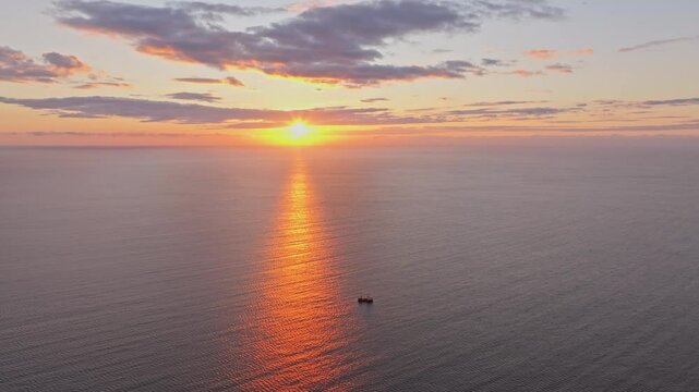 Aerial view of serene sunrise over the black sea with a fishing vessel, Nesebar, Bulgaria.