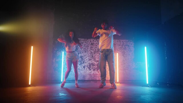 Male dance teacher and female student dancing together in dance studio, portrait . African American people enjoying music and rhythm of ethnic and modern song, professional dancers rehearsing show