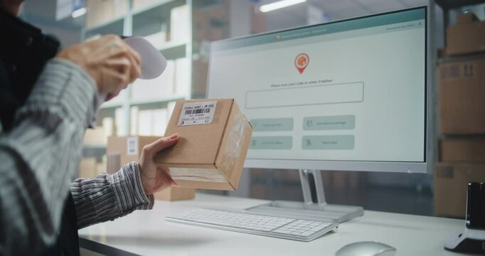 Female Logistics Specialist Scans Code on Cardboard Box with Scanner, Checks Parcel Information. Computer Screen Shows Delivery Tracking System for Monitoring Package with Online Orders. Close Up.