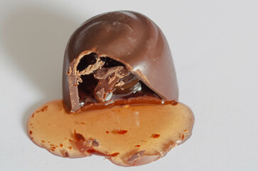 Macro Shot of Melting Chocolate with Gooey Liquid Filling,macro image of a partially broken chocolate truffle with rich liquid filling oozing out. 