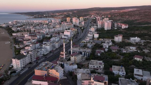 Aerial view of Antik Kiz Kalesi at sunrise over the Mediterranean Sea with beautiful coastline and historic mosque, Kizkalesi, Turkey.