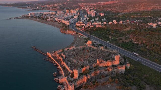 Aerial view of ancient Antik Kiz Kalesi at sunrise over the tranquil Mediterranean Sea, Kizkalesi, Turkey.