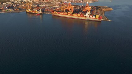 Thessaloniki, Greece - 01 December 2024: Aerial view of port with cargo ships and cranes at sunset, Thessaloniki, Greece.