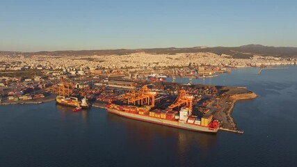 Thessaloniki, Greece - 01 December 2024: Aerial view of port with ships and cranes at sunset, Thessaloniki, Greece.