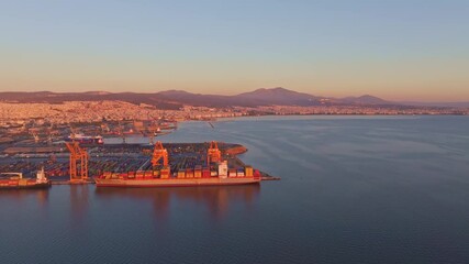 Thessaloniki, Greece - 01 December 2024: Aerial view of port at Aegean Sea during sunset with beautiful skyline and containers, Thessaloniki, Greece.