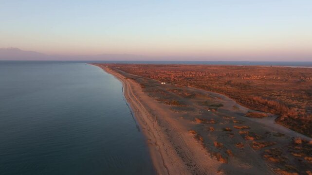Aerial view of serene Aegean Sea at sunrise with beautiful beach and tranquil shoreline, Epanomi, Greece.