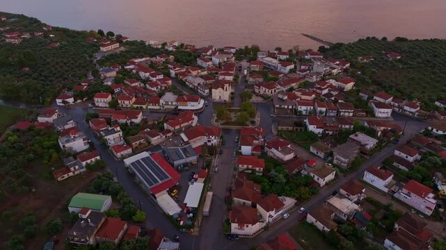 Aerial view of a picturesque village with charming rooftops and tranquil streets overlooking the Ionian Sea at sunset, Nea Koroni, Greece.