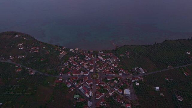 Aerial view of a picturesque village by the tranquil Ionian Sea at sunset, Nea Koroni, Greece.