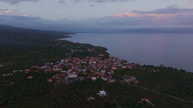 Aerial view of a picturesque village by the Ionian Sea during sunset, Nea Koroni, Greece.