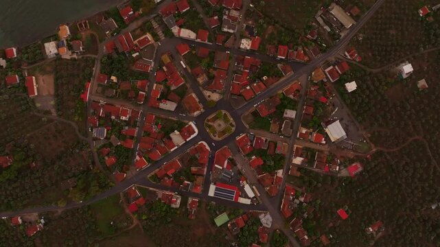 Aerial view of a beautiful village at sunset with scenic rooftops and coastal landscape, Nea Koroni, Greece.