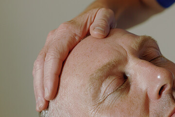 Naklejka premium tranquil close up of massage therapist hand gently applying pressure on client head, promoting relaxation and well being