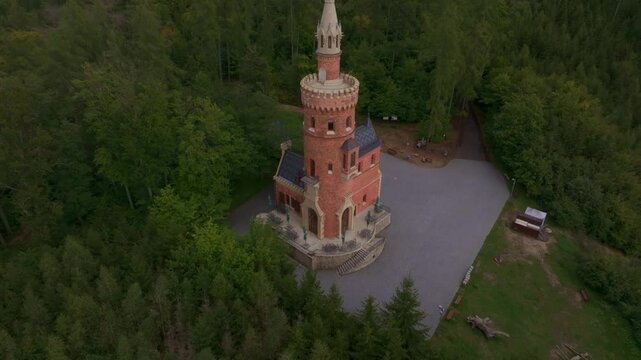 Aerial view of goethe's lookout tower surrounded by autumn trees and lush forest, karlovy vary, czech republic.