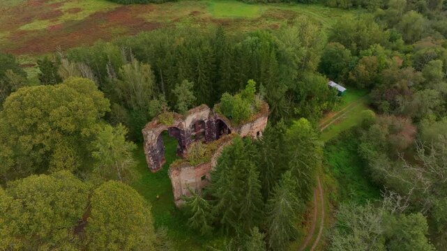 Aerial view of the historic St. Jana Krtitele church ruin surrounded by lush greenery and trees, Kocov, Czech Republic.