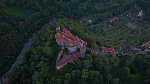 Aerial view of pernstejn castle at sunset surrounded by lush forest and scenic landscape, nedvedice, czech republic.