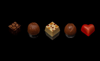 Set of five chocolate candy on black table