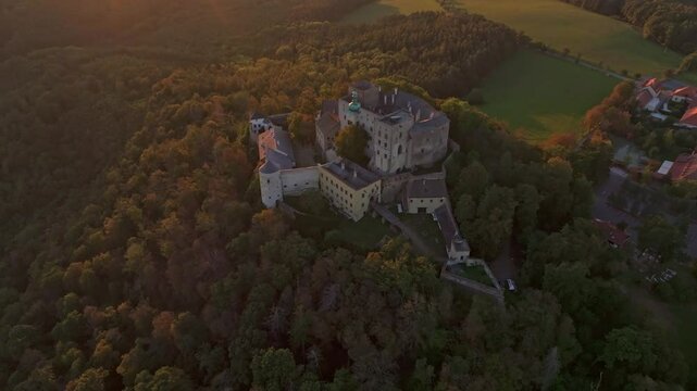 Aerial view of buchlov castle at sunset surrounded by forest and hills, buchlovice, czech republic.