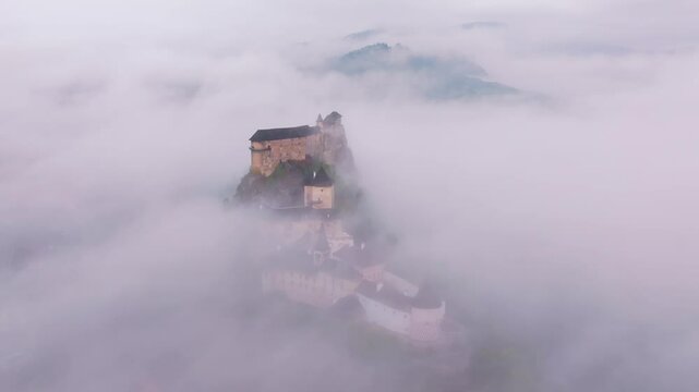 Aerial view of Orava Castle shrouded in fog at sunrise, Oravsky Podzamok, Slovakia.