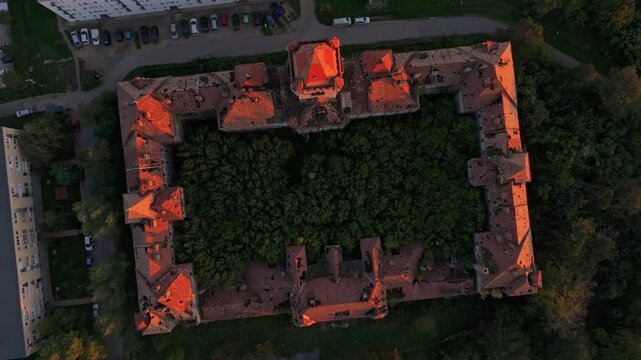 Aerial view of abandoned Hajmaskeri tuzerlaktanya artillery barracks surrounded by overgrown greenery at sunset, Hajmasker, Hungary.