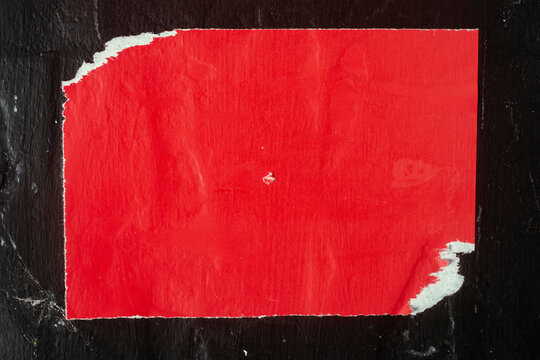 Old red poster on a black wall.
