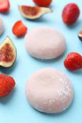 Delicious mochi, strawberries and figs on light blue background, closeup