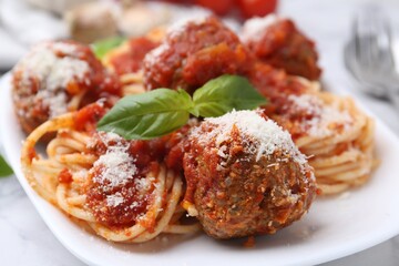 Delicious pasta with meatballs, basil and cheese on white table, closeup