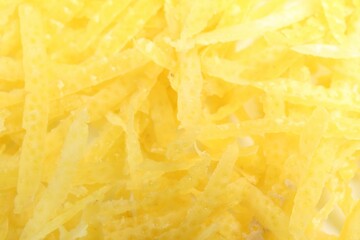 Fresh lemon zest as background, closeup view