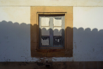 Sombra de tejado sobre ventana en casa de pueblo © Darío Peña