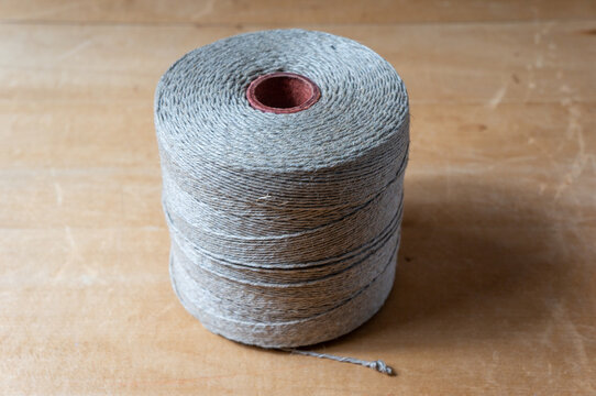 spool of twine rope on wooden table