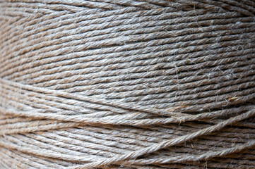 spool of twine rope on wooden table, close up