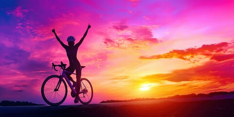 Obraz premium Silhouette of a cyclist celebrating against a vibrant sunset sky.