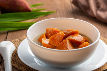 Coconut Milk Stewed orange yam,Thai dessert boiled sliced Sweet Potato in coconut milk with sugar in white bowl.