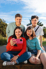 Group of young students taking a selfie in the park