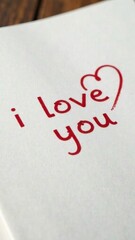 A handwritten inscription, the text "I love you" on a white sheet of paper, in a notebook or diary. A painted heart. A declaration of love. Romantic card for Valentine's Day, Mother's Day.