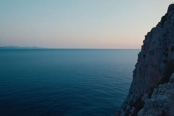 Cliffs tower over the tranquil sea at dusk, with colorful coastal plants thriving along the edge, illuminated by the soft glow of the fading sunset
