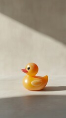 Yellow rubber duck resting on white surface with natural light